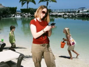 Woman texting on beach 